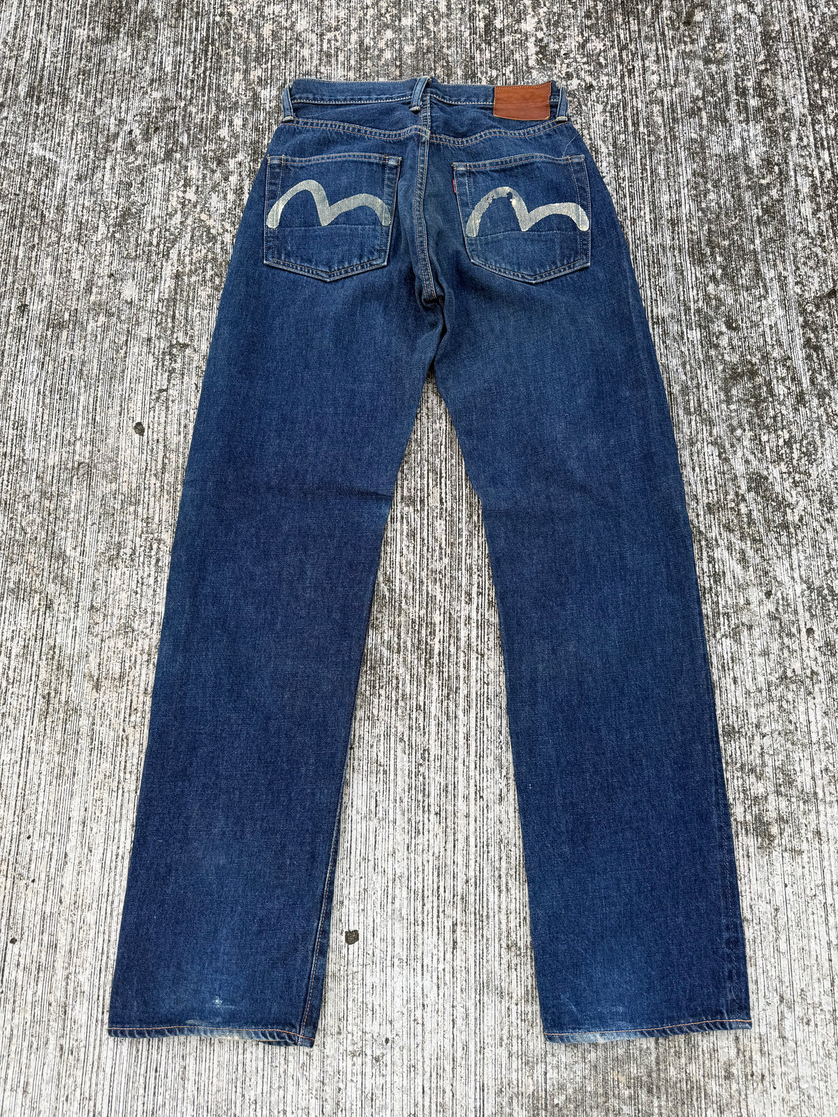 Vintage Evisu jeans showing faded indigo denim and painted white gulls across the back pockets